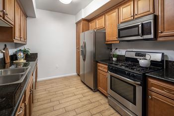 A kitchen with stainless steel appliances and wooden cabinets